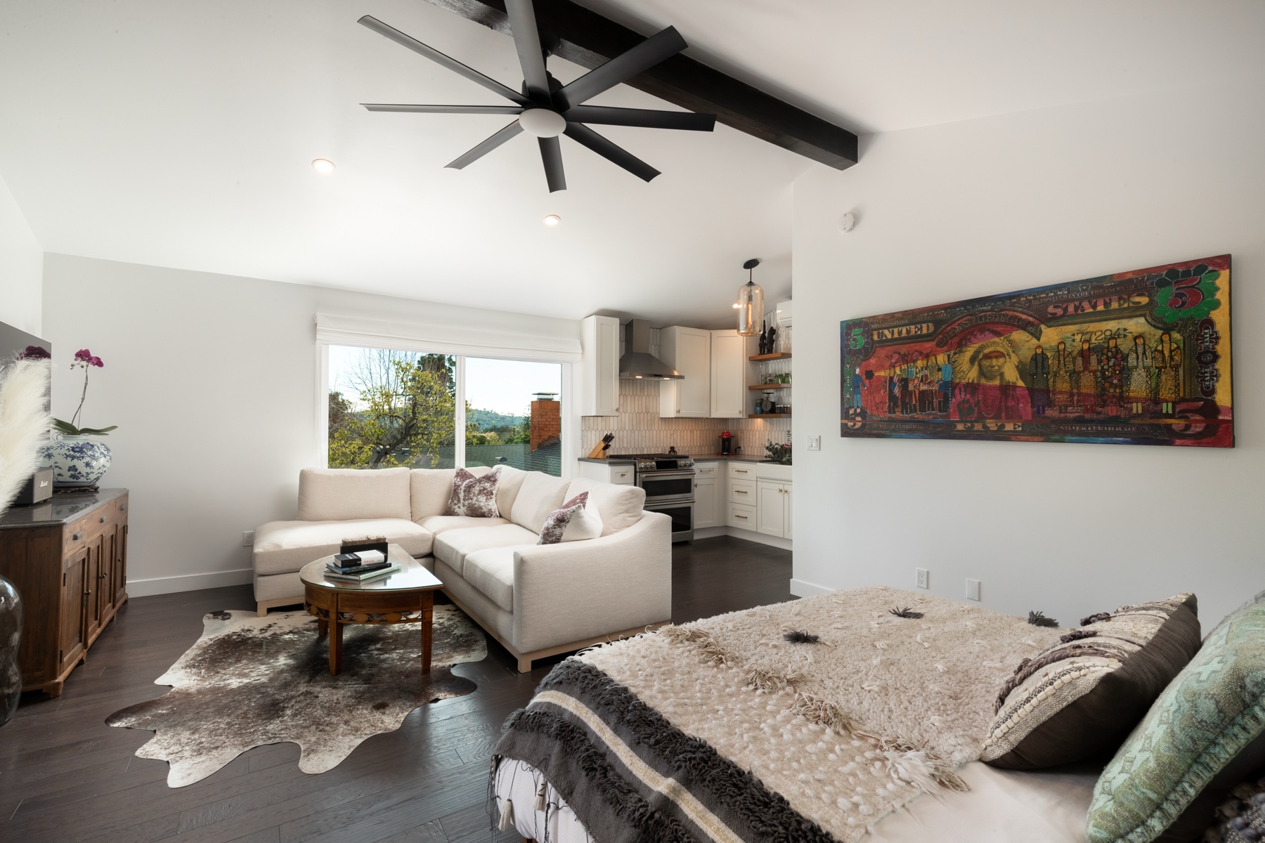 Open plan living space with vaulted beam ceiling and custom kitchen